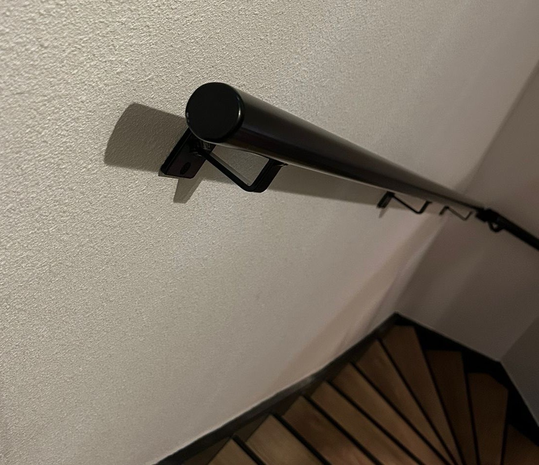 Detail van de einddop en bevestiging van een ronde stalen leuning