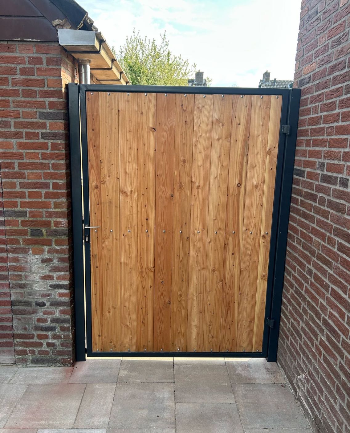Stalen poort met houten vulling tussen twee muren in Gendringen